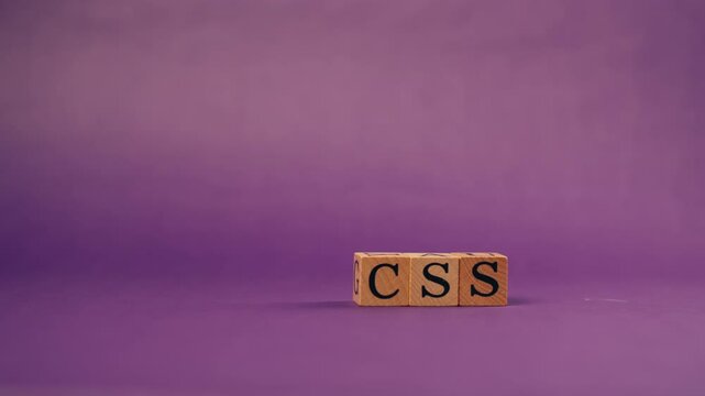 purple warm background with shadows wooden cubes with black letters and laid out words from letters CSS