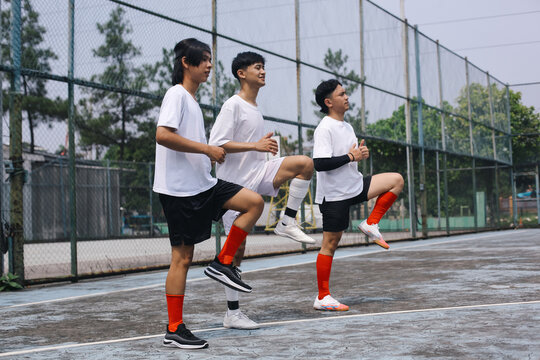 Side View Of Futsal Players Doing Knee Raises, Warming Up On The Field Before The Match