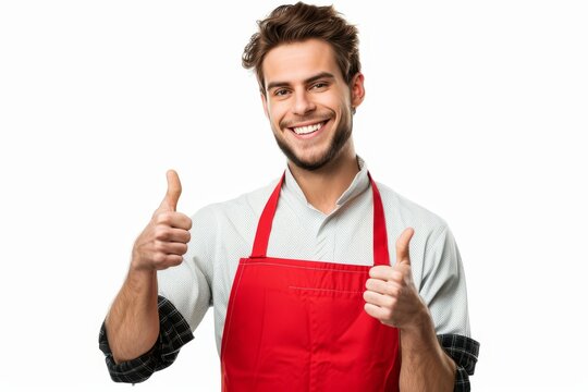 Joyful man in red apron gives thumbs up on white backdrop