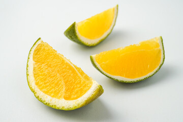 Three slices of fresh green colored orange (citrus sinensis) isolated on white background.