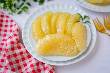 Peeled Pomelo it is a beneficial fruit and high in vitamin c  , in white plateon white table