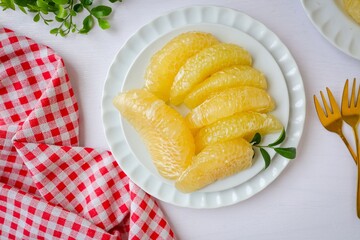 Peeled Pomelo it is a beneficial fruit and high in vitamin c  , in white plateon white table