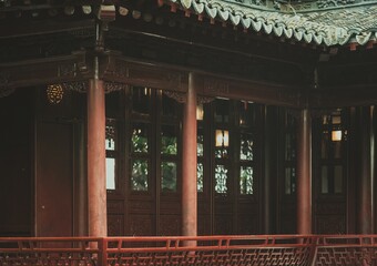 A close-up view of a traditional Chinese wooden structure with carved details and a red railing.