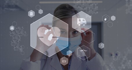 Image of digital icons data processing over caucasian female doctor in face mask