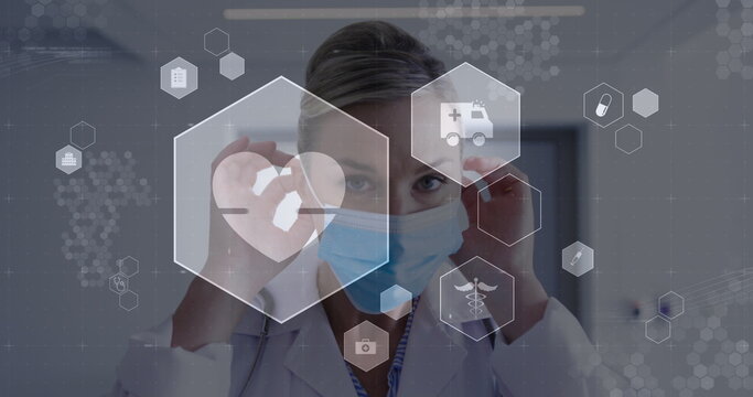 Image of digital icons data processing over caucasian female doctor in face mask