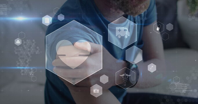 Image of digital icons data processing over caucasian man rubbing arm - Powered by Adobe