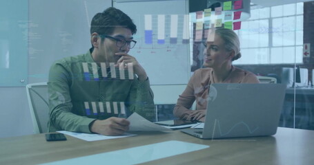 Image of graphs and globes over diverse coworkers discussing reports on laptop in office