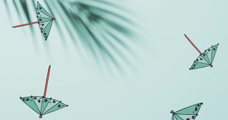 Naklejka premium Composition of green cocktail umbrellas falling over palm tree leaves on green background