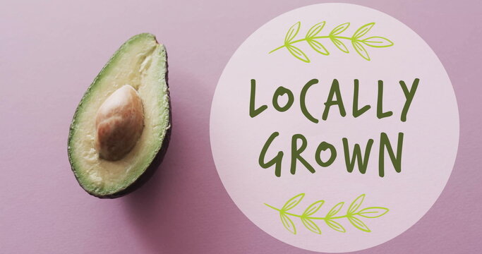 Image of locally grown text on circle over avocado on pink background