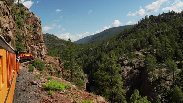 Durango and Silverton Train under river cliffs Narrow Gauge Railroad steam coal Colorado Rocky Mountains Neddleton Need Creek Chicago Basin Purgatory Trail Summer July bluesky forest follow pan