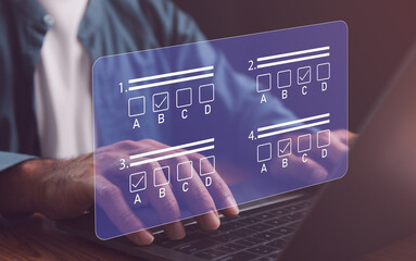 Businessman using laptop filling online survey exam Choosing the right answer in the exam, filling out an online survey form. Online test or exam, pass exam on internet, choose correct answer.
