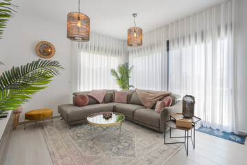 Bright living room with a comfortable sectional sofa, decorative pillows, modern lighting, and stylish accents, creating a cozy ambiance