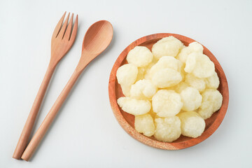Javanese traditional snacks, Fried geblek served on wooden plate next to wooden spoon and fork. Isolated on white background.