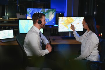 Center of dispatching maintenance. Portrait of cheerful woman and man working via headset...