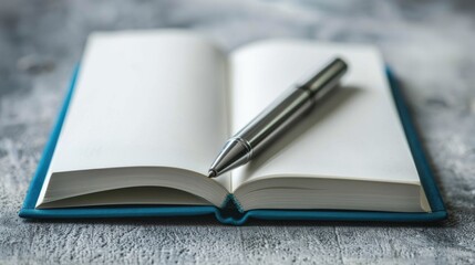 Open notebook with silver pen on textured surface for inscription Close up