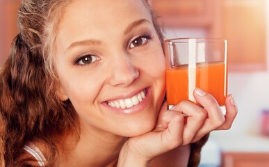 A young happy healthy woman drinks juice.
