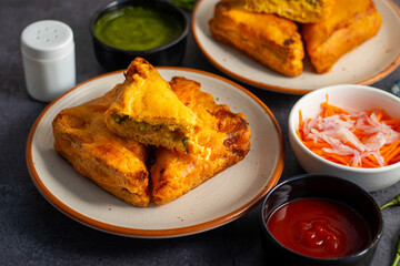 Selective Focus of Bread pakora is a popular Indian street food made with bread, stuffed with spicy potato filling, coated in chickpea flour, and deep-fried.