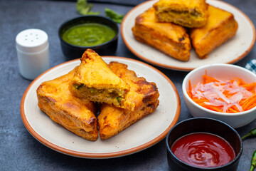 Selective Focus of Bread pakora is a popular Indian street food made with bread, stuffed with spicy potato filling, coated in chickpea flour, and deep-fried.