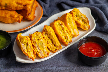 Selective Focus of Bread pakora is a popular Indian street food made with bread, stuffed with spicy potato filling, coated in chickpea flour, and deep-fried.