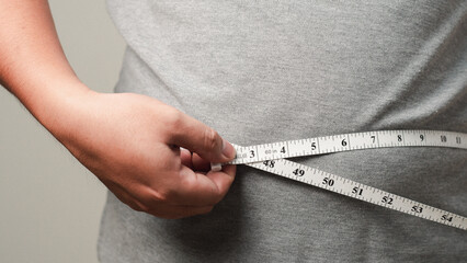 Overweight or obese man on white background. Fat mens body measurements. he is dieting and losing weight. Healthcare, medicine concept. he is dieting and losing weight.