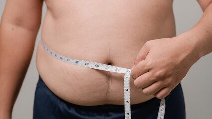 Overweight or obese man on white background. Fat mens body measurements. he is dieting and losing weight. Healthcare, medicine concept. he is dieting and losing weight.
