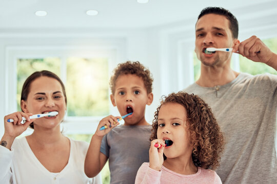 Family portrait, parents and kids in bathroom for brushing teeth, healthcare and bonding to start morning in house. Father, mother and children with toothbrush, smile and health for medical self care
