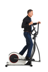 Mature businessman on exercising bike against white background