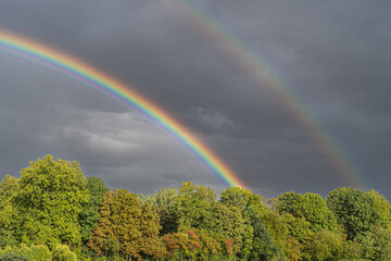 Zwei Regenbogen vor einer Gewitterwolke.