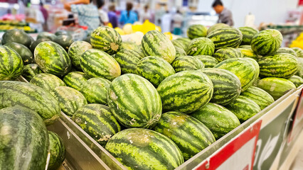 Stack of Watermelons. Watermelons on supermarket shelf. Fresh organic water melon fruit for sale in grocery store. Ripe and fresh watermelons piled up in a store. A lot of watermelons