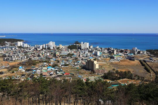 Jinha-ri, Ulju-gun, Ulsan, South Korea - May 13, 2023: High angle and spring view of houses and apartment near Jinha Beach against sea horizon
