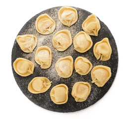 Black board with raw dumplings on white background