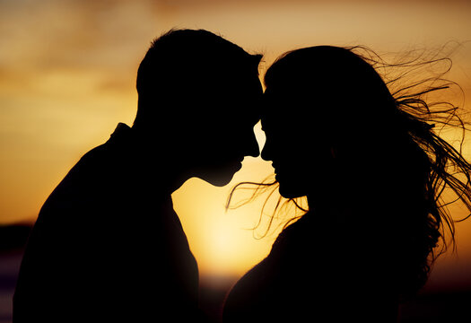 Sunset, silhouette or couple touching forehead for love, trust or kiss on honeymoon. Man, woman or shadow in nature with hug, passion or support in relationship on trip for milestone or celebration