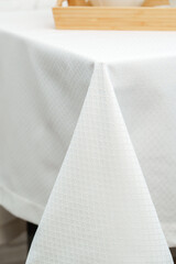 White Textured Tablecloth Draped Over Black Table Leg