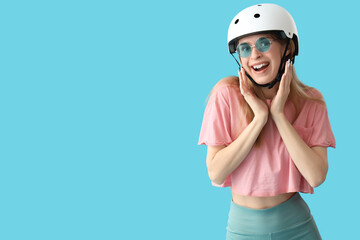 Beautiful young woman in helmet on blue background