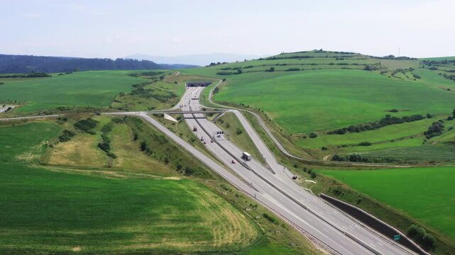 Drone shot of European route E50 highway through green agricultural fields landscape connecting European continent, Levoca