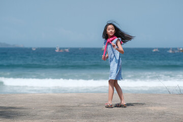 Little girl walking on the sands alone at the seashore of Banyuwangi beach.