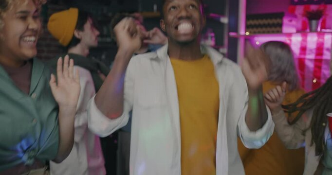 Slow motion of playful young people friends dancing and fooling around chilling at party at home. Modern lifestyle and leisure activity concept.