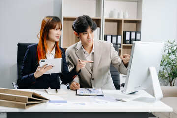 Asian business people working together in modern office. Couple teamwork startup concept.