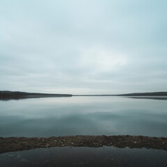 Obraz premium view of a lake, overcast sky, sparse clouds, symmetrical, photography