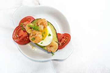 Shrimps, egg, avocado and tomato with parsley garnish, healthy low carb snack, rich in protein and unsaturated fatty acids, nearly white background, top view from above, copy space