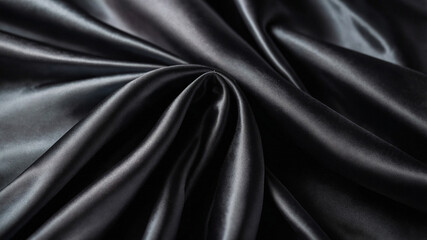 Sleek black silk fabric draped gracefully, creating an elegant and luxurious appearance in the image.