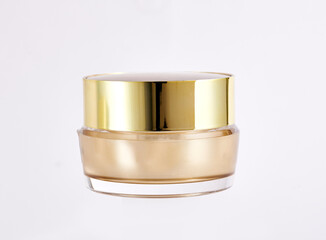 golden color cosmetic jar with containing moisturizing cream, isolated on white background