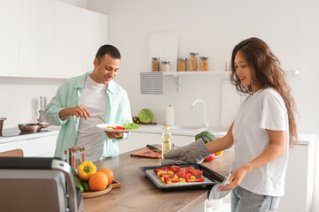 Young couple with cooked meal in kitchen