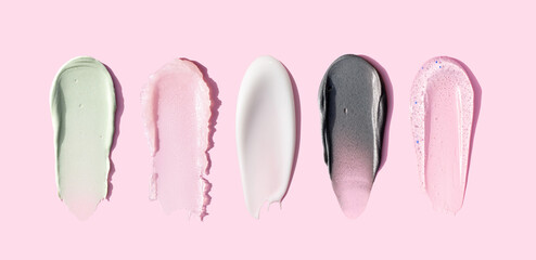 creamy texture of cosmetic samples on pink background