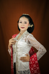 A young Indonesian woman with a happy expression wearing a white kebaya. Kartini's Day Concept.