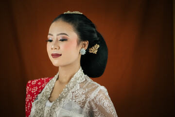 A young Indonesian woman with a happy expression wearing a white kebaya. Kartini's Day Concept.