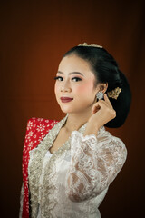 A young Indonesian woman with a happy expression wearing a white kebaya. Kartini's Day Concept.
