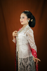 A young Indonesian woman with a happy expression wearing a white kebaya. Kartini's Day Concept.