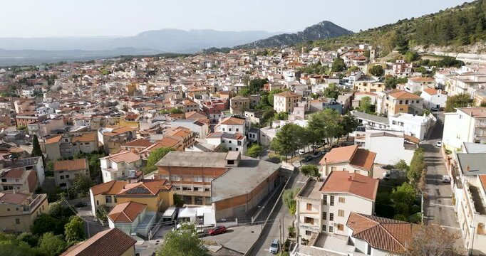 Village Of Dorgali In Sardinia, Italy. Pull Back Aerial Shot Of Homes And Mountains.