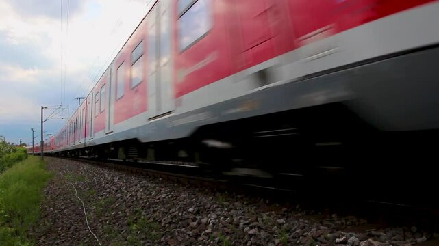Deutsche Bahn train speeding through a lush countryside under a cloudy sky